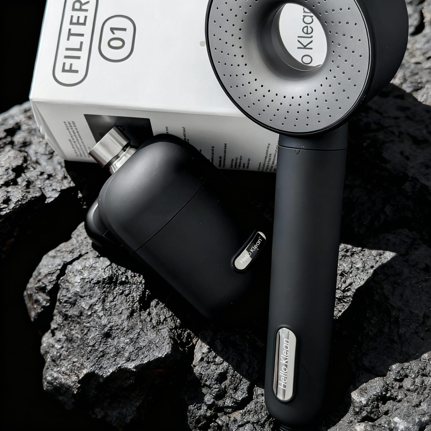 HelloKlean showerhead, filter capsule and Filter 01 box on dark stone